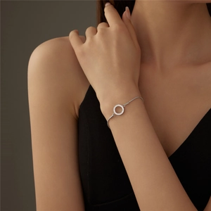 Classic silver bracelet with a sparkling round pavé pendant on a model's wrist