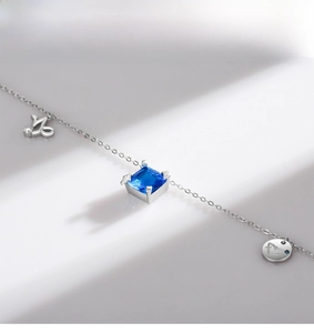 Close-up of S925 silver chain with square blue gemstone and rabbit charm detail