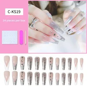 Vue macro de faux ongles de style cercueil français avec des paillettes argentées et strass
