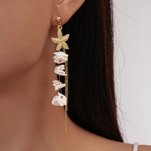 Detail of starfish stud earring with white shell pendants and golden tassel chain