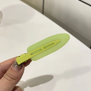 Detail of lime green translucent matte resin hair clip with metal duckbill clasp base