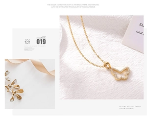 Macro detail of gold butterfly pendant with sparkling diamonds on a fine link chain