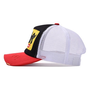 Detailed view of tricolor trucker hat with distressed brim and breathable white mesh