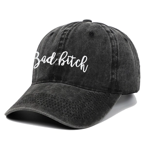 Close-up of small white embroidery on a dark grey washed denim baseball cap detail
