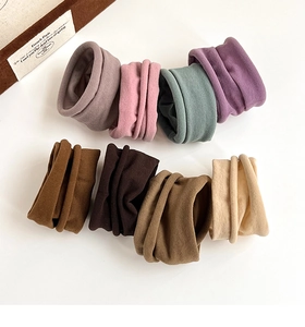 Close-up of eight Morandi-colored elastic hair ties arranged on a clean white background