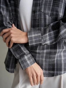 Détail des poignets boutonnés et des coutures sur une chemise en flanelle grise