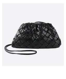 Detail of black woven leather texture on a soft pleated cloud shoulder bag with thin strap