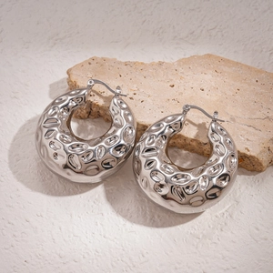 Vue détaillée de boucles d'oreilles créoles argentées avec finition martelée