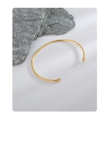 Detail view of gold S925 silver adjustable open bangle with two sparkling zircon stones