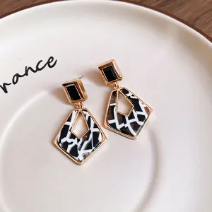 Boucles d'oreilles carrées en acétate léopard avec diamants sur plateau céramique