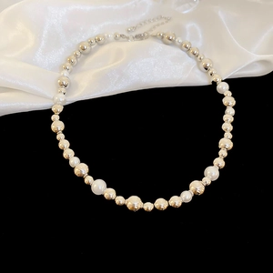 Detailed macro view of the pearl and metallic bead necklace with lobster clasp and chain