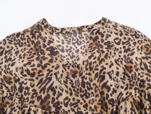 Dettaglio ravvicinato dello scollo a V e della trama leopardata su abito in chiffon