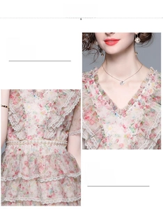Détail du col en V et de la ceinture perlée sur une robe fleurie à volants