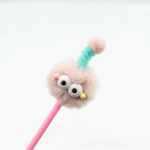 Close-up of cute pink monster ballpoint pen with fluffy head and cyan mini hat decoration