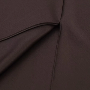 Macro shot of dark brown satin fabric texture with precise stitching details on the set