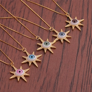 Détail de pendentifs œil maléfique colorés de style soleil doré sur chaînes fines
