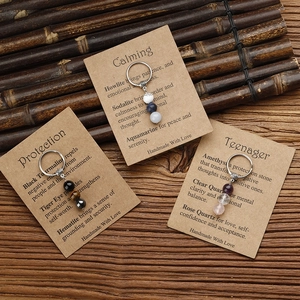 Handmade stone beaded keychains with tiger eye and sodalite on natural bamboo background