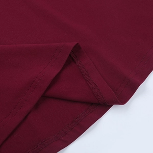 Détail macro du tissu en maille rouge vin montrant les coutures et la texture de qualité