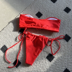 Detailed view of red bandeau bikini set with white pads and side-tie swim bottoms