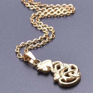 Macro detail of gold-plated cat pendant featuring an intricate Celtic knot design