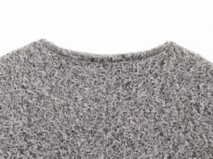 Détail macro du col gris en fausse fourrure montrant la texture bouclée haute densité