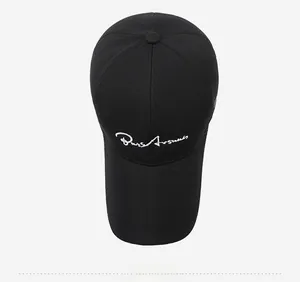 Top down view of a black baseball cap with white cursive script embroidery detail