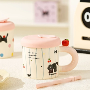 Detail of creative ceramic cat mug with black cat patterns and 3D red apple handle