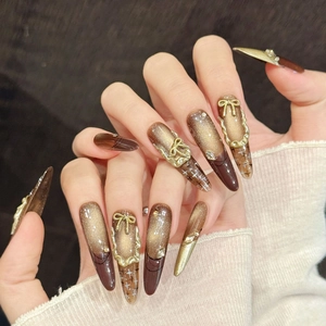 Brown cat eye press-on nails with golden 3D bows and vintage long stiletto shape