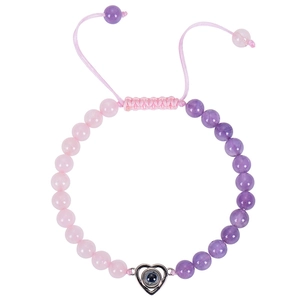 Detail of pink and purple beaded bracelet with a heart projection stone charm