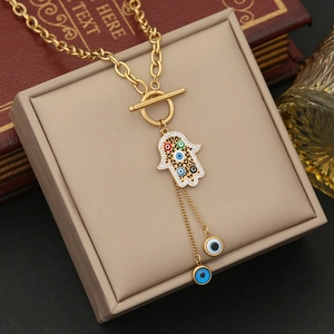 Détail du collier main de Fatma dorée avec œil protecteur sur une boîte à bijoux