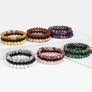 Set of six 8mm natural stone bead bracelets displayed on white tiered steps
