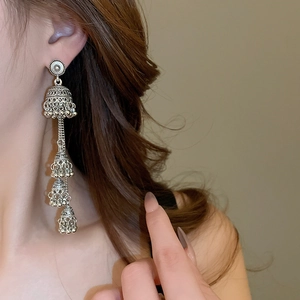 Detail view of silver vintage Jhumka bell earrings with elegant tassel fringe on a model