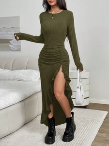 Detail of dark green knit dress showing side ruching and asymmetric ruffled slit hemline