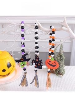 Dettaglio di ghirlanda in perle di legno di Halloween con ciondoli strega e zucca