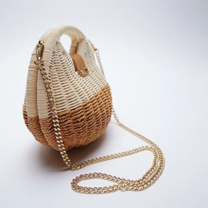 Detail of beige and brown woven shell bag with leather buckle and gold chain strap