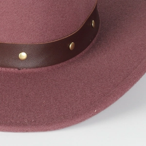 Macro detail of wool fedora hat with brown leather band and gold metal rivets
