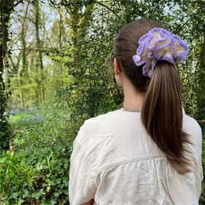 Detail of hand-crocheted purple and beige ruffle scrunchie for women hair styling