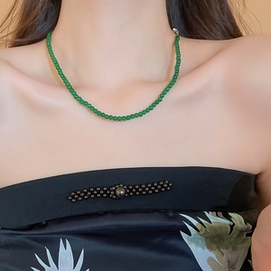 Gros plan d'un collier de perles vertes sur mannequin au style vintage élégant