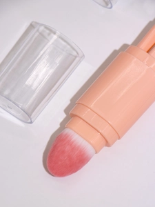 Detail of pink 5-in-1 retractable makeup brush with bristles and clear protective cap