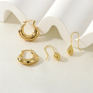 Detail view of gold earrings set featuring textured hoops and teardrop pendants