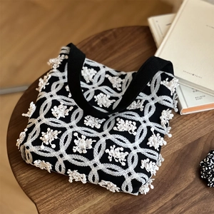 Detailed embroidery texture and white fringe on vintage black canvas tote bag