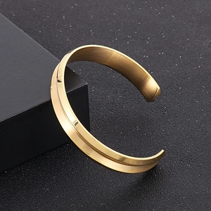 Dettaglio del bracciale in acciaio inossidabile dorato a C con finiture opache e lucide