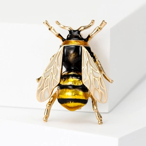 Detailed close-up of a gold-tone bee brooch with yellow and black enamel stripes