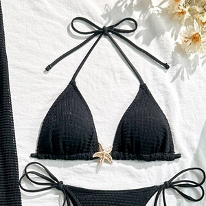Close-up of black waffle textured bikini top featuring a gold starfish hardware detail