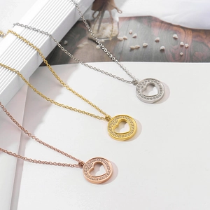Detail of heart pendants in gold, silver, and rose gold with pavé crystals on the edge