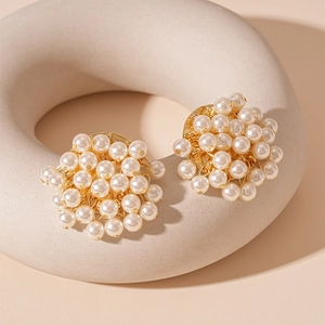 French vintage round faux pearl stud earrings in gold setting on a stone tray