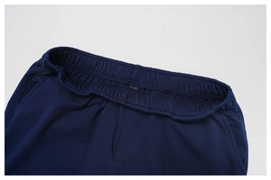 Detailed close-up of wide elastic waistband and stitching on navy high-waisted sweatpants