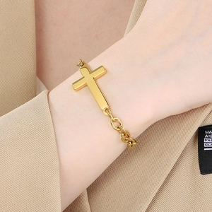 Minimalist gold stainless steel cross bracelet on wrist with elegant O-link chain