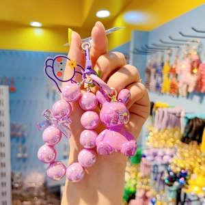Detail of purple bunny charm with beaded chain and bow keychain for bags and phones