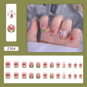 Press-on-Nägel mit rosa Verlauf, grünen French-Tips und weißen 3D-Schleifen